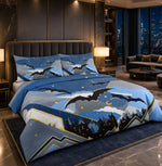 A bed dressed in a blue and gray night-sky themed duvet cover and pillowcases, featuring silhouettes of bats, crescent moons, and castle-like shapes, styled in a modern luxury bedroom with dark wood paneling and a city view at night.