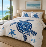 A bed dressed in a white duvet cover and matching pillowcases featuring a large blue sea turtle print, styled in a bright bedroom with ocean views visible through a window.
